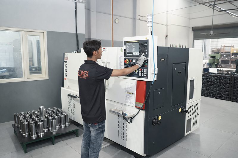 Operator at a CNC turning machine with machined components